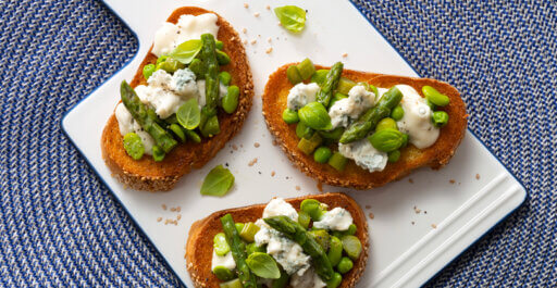 Pan tostado con guisantes, espárragos y habas, queso Gorgonzola DOP dulce y albahaca