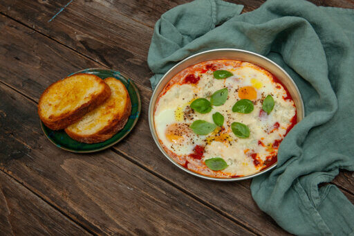 Huevos en bandeja con queso Gorgonzola DOP, tomate y cubitos de pan tostado